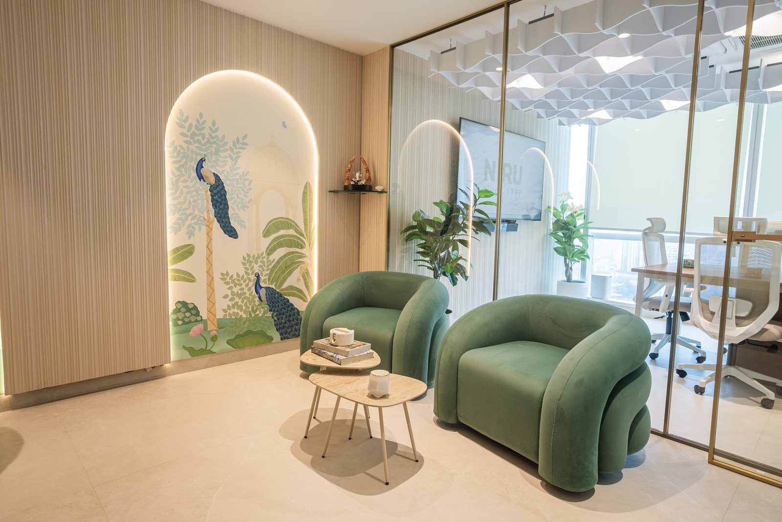 Sage velvet chairs beside an arched niche with a painted peacock