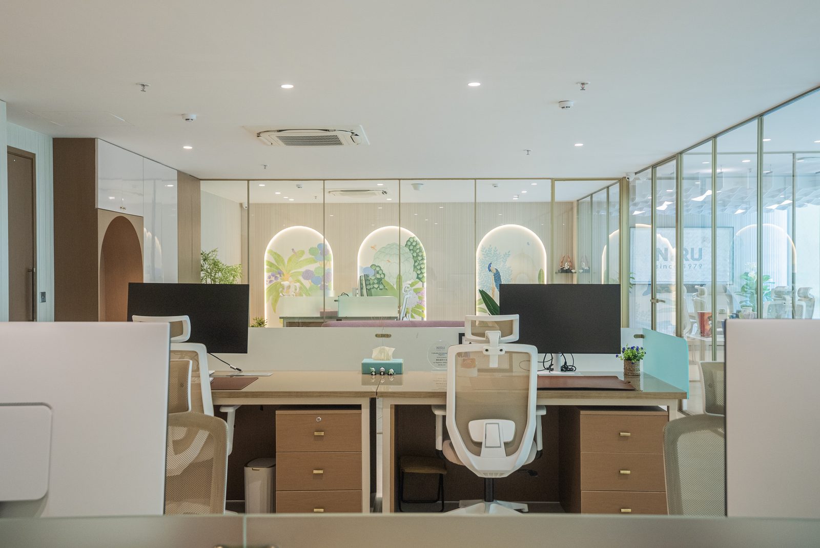 Workstations facing a wall of lit mural arches