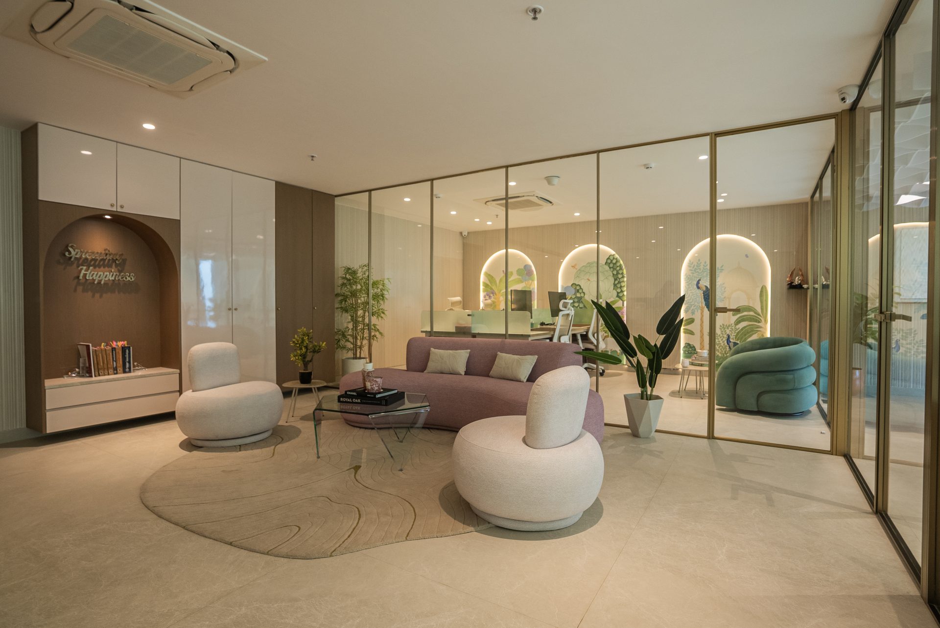 Niru India, the lounge with a mauve sofa, cream poufs and arched niches beyond gold framed glass