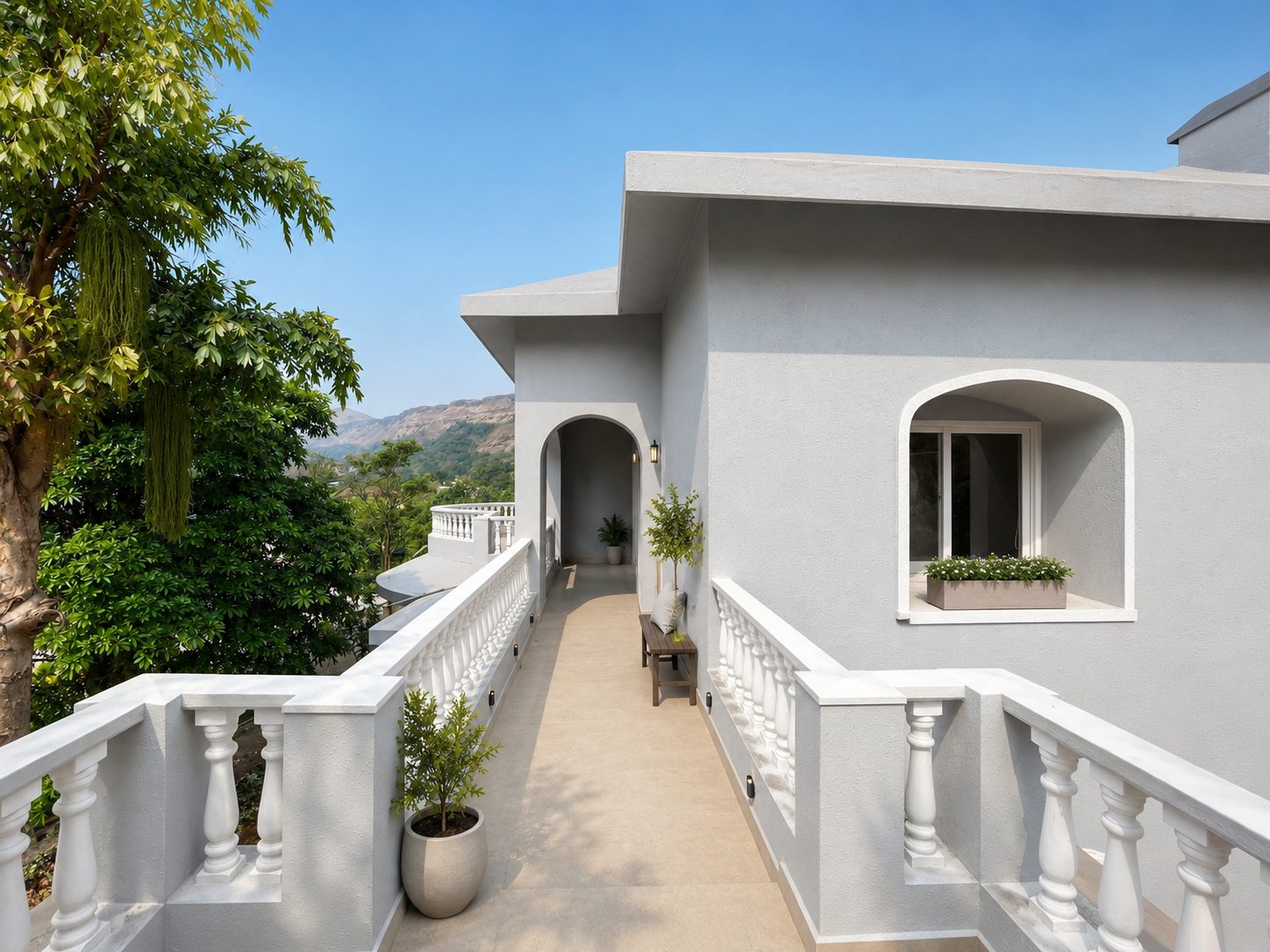 The upper terrace walkway with white balustrades and hills beyond